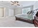 Bedroom featuring gray walls, carpet, large bed, ceiling fan, and windows overlooking the backyard at 646 Darlington Ne Cir, Atlanta, GA 30305