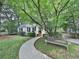 Charming home featuring a curved walkway, a bench, and mature trees and landscaping at 646 Darlington Ne Cir, Atlanta, GA 30305