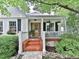 Inviting front porch with brick steps, white railing, and hanging plants, creating a cozy outdoor space at 646 Darlington Ne Cir, Atlanta, GA 30305