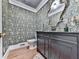 A stylish powder room with an ornate mirror and decorative wallpaper at 646 Darlington Ne Cir, Atlanta, GA 30305