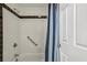 Close up of bathtub with shower featuring white tiles with black border at 1130 Piedmont Ne Ave # 402, Atlanta, GA 30309