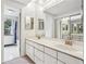 Bathroom featuring double sinks, mirrored wall, and doorway to tiled shower at 1130 Piedmont Ne Ave # 402, Atlanta, GA 30309