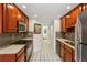 Galley kitchen features wood cabinets, stainless steel appliances, granite counters, and tiled floors at 1130 Piedmont Ne Ave # 402, Atlanta, GA 30309