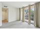 Bright living room with access to the hallway and a balcony with beige curtains and neutral carpet at 1130 Piedmont Ne Ave # 402, Atlanta, GA 30309