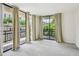 Light filled living room with beige curtains covering glass doors to balcony and neutral carpet at 1130 Piedmont Ne Ave # 402, Atlanta, GA 30309