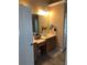 Bathroom featuring a vanity with a sink, mirror, and cabinet space; adjacent to a partially visible shower at 1450 Liberty Ln, Cumming, GA 30040
