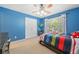 Bright bedroom featuring blue walls, a ceiling fan, and a neatly made bed with plenty of natural light at 1450 Liberty Ln, Cumming, GA 30040