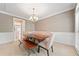 Elegant dining room with chandelier, wainscoting, and a large wooden table with seating at 1450 Liberty Ln, Cumming, GA 30040