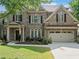 Charming brick home with a two-car garage, beautiful landscaping, and a welcoming front porch at 1450 Liberty Ln, Cumming, GA 30040