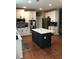 Beautiful kitchen with white cabinetry, a dark island, stainless steel appliances, and hardwood floors at 1450 Liberty Ln, Cumming, GA 30040