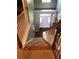 Carpeted staircase with wood railing, leading to a bright foyer with hardwood flooring and a white front door at 1450 Liberty Ln, Cumming, GA 30040