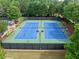 Overhead view of a community tennis court surrounded by greenery, showcasing recreational amenities at 1450 Liberty Ln, Cumming, GA 30040