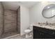 Bathroom featuring a single sink vanity and shower with wood look tile at 1749 W Caribaea Se Trl, Atlanta, GA 30316