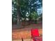 Backyard with wooden deck, mature trees, and fenced perimeter, offering a private and peaceful outdoor space at 222 Yardsley Dr, Mcdonough, GA 30253