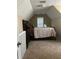 A cozy carpeted bedroom featuring a bed, nightstand and a window at 222 Yardsley Dr, Mcdonough, GA 30253