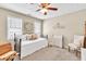 A sunlit bedroom featuring a ceiling fan, two windows, and charming decor accents at 3574 Timberloch Trl, Snellville, GA 30039