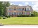 Charming two-story brick home featuring a manicured lawn, blue shutters, and a welcoming front entrance at 3574 Timberloch Trl, Snellville, GA 30039