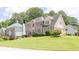 Well-maintained two-story home with brick and siding, complemented by a lush green lawn and manicured landscaping at 3574 Timberloch Trl, Snellville, GA 30039