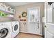 Well-organized laundry room with modern washer/dryer, shelving, and outdoor access at 3574 Timberloch Trl, Snellville, GA 30039