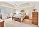 Spacious main bedroom with a tray ceiling, ceiling fan, and warm, inviting decor at 3574 Timberloch Trl, Snellville, GA 30039