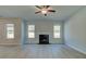 Bright living room features a fireplace, wood flooring, and large windows offering plenty of natural light at 112 Felicity Pike, Locust Grove, GA 30248