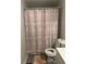 Cozy bathroom features a toilet, pink snowflake shower curtain, light gray walls, and gray wood-look flooring at 2351 Carver Nw Dr, Atlanta, GA 30314