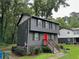 Charming gray two-story home with black shutters and a vibrant red front door, nestled among mature trees at 2351 Carver Nw Dr, Atlanta, GA 30314