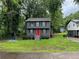 Charming two-story home featuring a gray exterior with a vibrant red front door and a well-maintained lawn at 2351 Carver Nw Dr, Atlanta, GA 30314