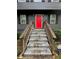 Close-up of a vibrant red front door with stairs and well-maintained surrounding landscape at 2351 Carver Nw Dr, Atlanta, GA 30314