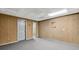 Basement featuring wood-paneled walls, gray carpeting, a white door, and recessed ceiling tiles at 3185 Country Club Nw Ct, Kennesaw, GA 30144