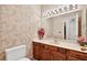 Bathroom with a wooden vanity, neutral countertop, and decorative wallpaper at 3185 Country Club Nw Ct, Kennesaw, GA 30144