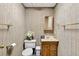Bathroom showcasing a toilet, vanity with mirror, and wallpapered walls at 3185 Country Club Nw Ct, Kennesaw, GA 30144