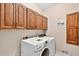 Laundry room with upper wood cabinets, and side by side machines at 3185 Country Club Nw Ct, Kennesaw, GA 30144