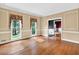 Bright living room with hardwood floors, large windows with decorative curtains, and elegant wall trim at 3185 Country Club Nw Ct, Kennesaw, GA 30144