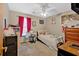 This bedroom features a ceiling fan, a window with curtains, a bed, and playful decor at 3902 Cedarwoods Way, Lawrenceville, GA 30044