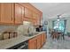 Functional kitchen featuring tile countertops, a stainless steel sink, and an adjacent dining area at 3902 Cedarwoods Way, Lawrenceville, GA 30044