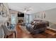 Comfortable living room featuring hardwood floors, a ceiling fan, and a stone fireplace at 3902 Cedarwoods Way, Lawrenceville, GA 30044