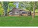 Exterior view showcasing wood siding, a screened porch, and lush green lawn at 3961 Jodeco Rd, Mcdonough, GA 30253