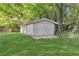 Detached garage with painted wood, featuring double doors and green lawn at 3961 Jodeco Rd, Mcdonough, GA 30253