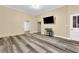 Living room featuring gray vinyl floors, a large mounted television, and neutral walls at 3961 Jodeco Rd, Mcdonough, GA 30253
