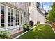 Brick and stucco home exterior, a gas grill, lush artificial turf, and a double french doors add charm to this cozy outdoor space at 54 Camden Ne Rd, Atlanta, GA 30309