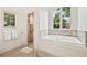 Bright bathroom featuring a soaking tub, walk-in shower, and windows at 54 Camden Ne Rd, Atlanta, GA 30309