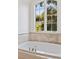 Close-up on a bright soaking tub with a large window overlooking greenery at 54 Camden Ne Rd, Atlanta, GA 30309