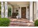 Inviting front porch with brick steps, a wooden bench, and a decorative wreath on the door at 54 Camden Ne Rd, Atlanta, GA 30309