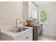 Well-lit laundry room with modern washer, dryer, sink, and ample storage cabinets, conveniently located and efficiently designed at 54 Camden Ne Rd, Atlanta, GA 30309