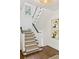 Elegant staircase with dark wood floors, white trim, a window, and artwork at 54 Camden Ne Rd, Atlanta, GA 30309