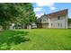 Expansive backyard with lush green lawn, storage shed, and a view of the home's rear elevation at 335 Lee Miller Ct, Suwanee, GA 30024