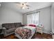 Comfortable bedroom featuring a cozy sofa, bed with a colorful quilt, and light-filled window at 335 Lee Miller Ct, Suwanee, GA 30024