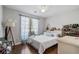 Cozy bedroom with hardwood floors, a full-sized bed, bedside table and shoe rack at 335 Lee Miller Ct, Suwanee, GA 30024