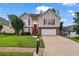 Charming two-story home with red shutters, two-car garage, green lawn, and inviting red front door at 335 Lee Miller Ct, Suwanee, GA 30024